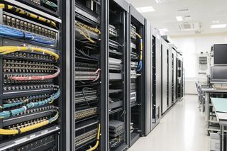 放送局のマスタールームに並ぶ機器ラックと同軸・光ファイバーのケーブル群